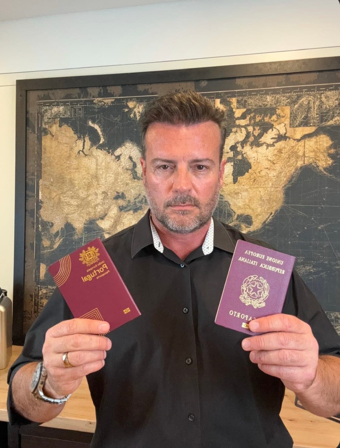 Dr. Rodrigo Maricato Lopes segurando os passaportes português e italiano diante de um mapa-múndi